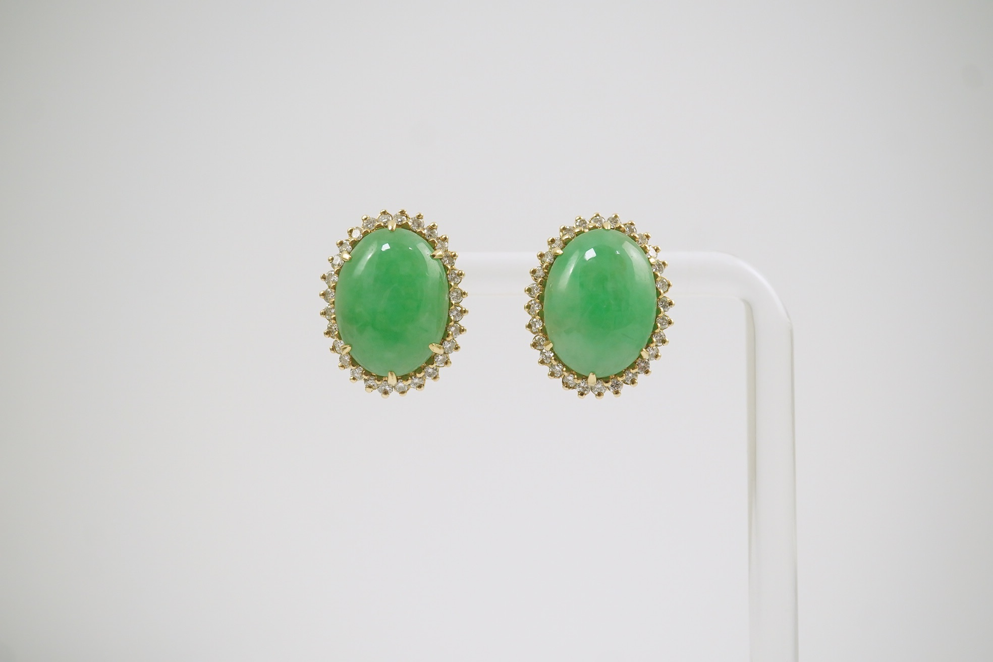 A pair of mid 20th century gold, cabochon jade and diamond cluster set oval earrings